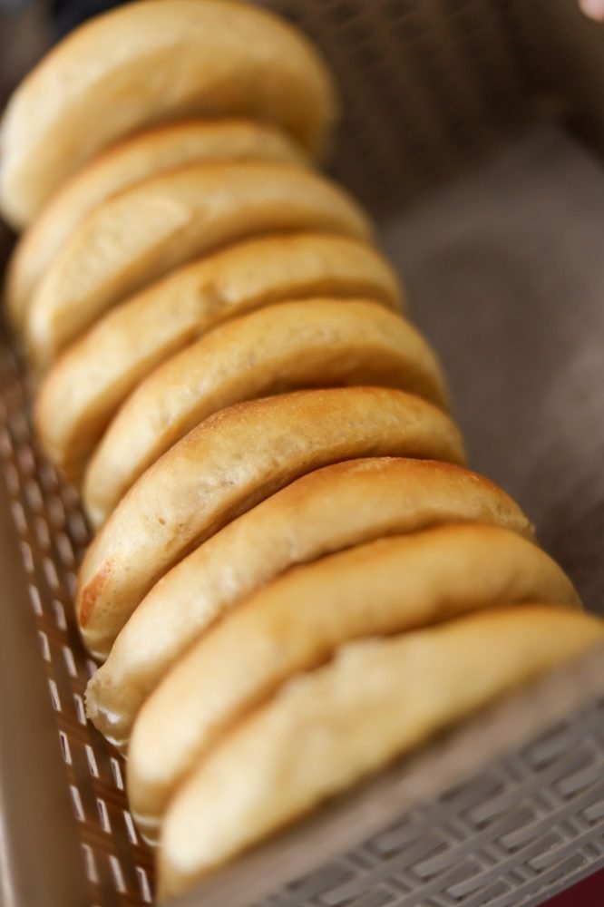 Soft bread rolls lined up in the bakery tray
